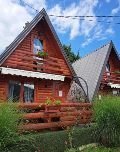 a log cabin with a porch and a window at Konak kod Tose in Banja Luka