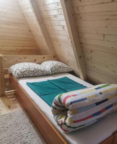 a small bed in a wooden cabin with a mattress at Konak kod Tose in Banja Luka