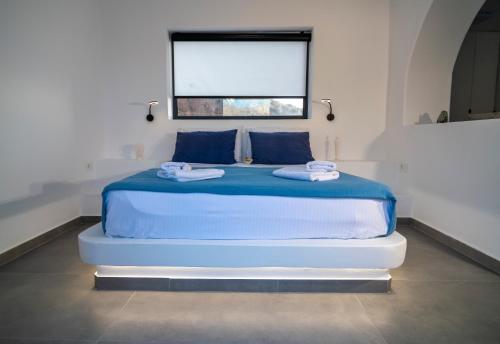a blue bed in a white room with a window at Shape-Meander in Kalymnos
