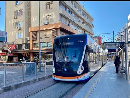 eine blaue und orangefarbene Straßenbahn auf einer Stadtstraße in der Unterkunft Two bedroom Apartment in Center Antalya near Shopping Center MarkAntalya in Antalya