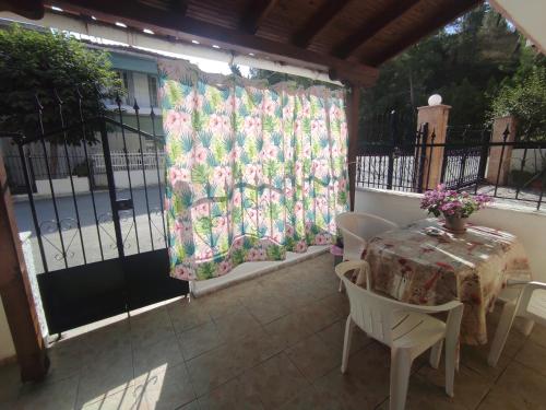 a patio with a table and chairs and a curtain at Niki's house 1 in Agia Triada