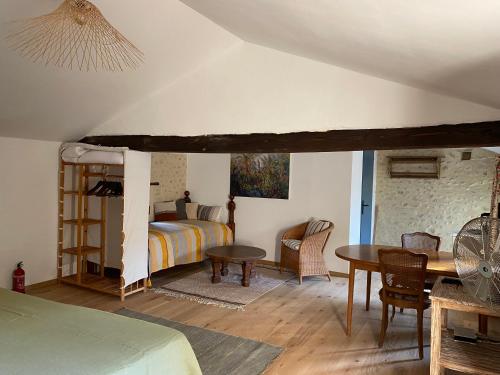 ein Schlafzimmer mit einem Bett und einem Tisch in einem Zimmer in der Unterkunft Otarkia in Vaison-la-Romaine