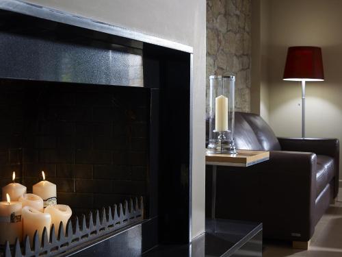 a fireplace with candles in a living room at Anaxo Resort in Riglia
