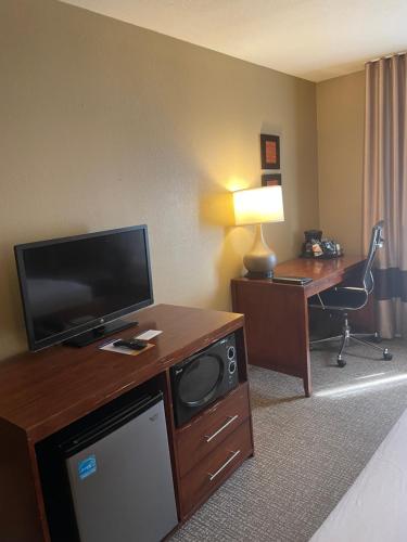 a hotel room with a television and a desk with a computer at Comfort Inn Ellensburg in Ellensburg