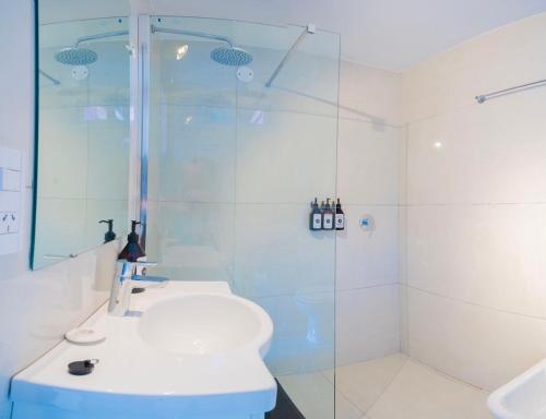 uma casa de banho com um chuveiro, um WC e um lavatório. em Destinar Apartments em San Carlos de Bariloche