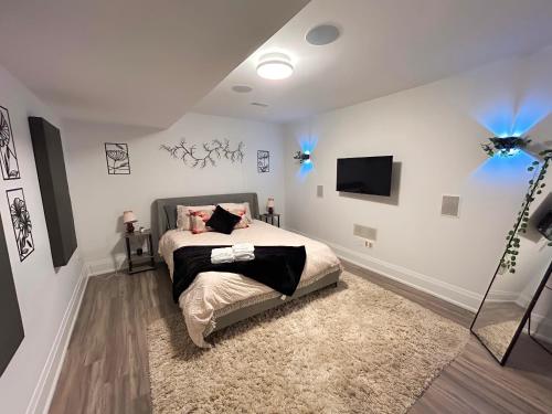 um quarto com uma cama e uma televisão na parede em Boho-chic Spacious Basement Apartment em Toronto