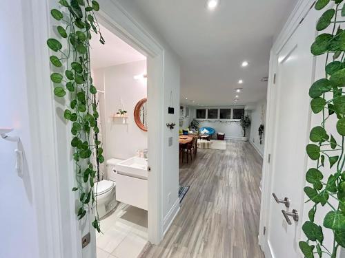 cocina y sala de estar con paredes y plantas blancas en Boho-chic Spacious Basement Apartment en Toronto