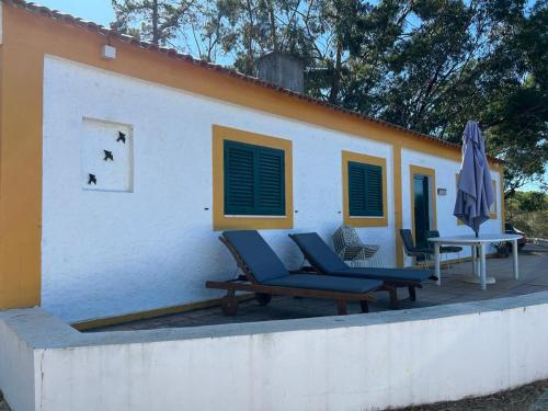 a patio with chairs and an umbrella and a building at Paradise Villa for 6 at Odemira River&Country in Santa Clara-a-Velha