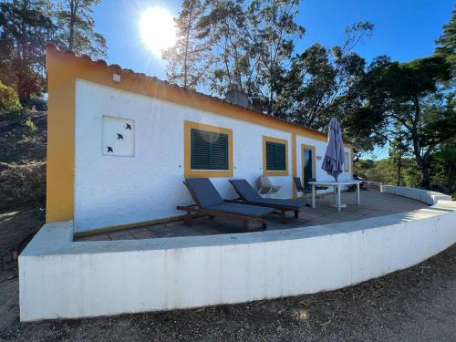 a small house with two chairs and an umbrella at Paradise Villa for 6 at Odemira River&Country in Santa Clara-a-Velha
