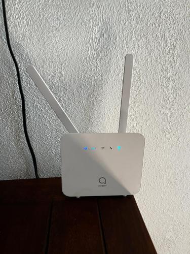 a white router sitting on top of a table at Villa unter Palmen in Jarabacoa
