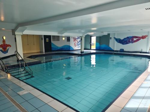 a large indoor swimming pool with blue tile floors at Highway in Lossiemouth