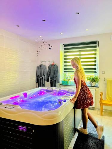 a woman standing in front of a hot tub at Les étangs du moulin d'Harcy in Lonny