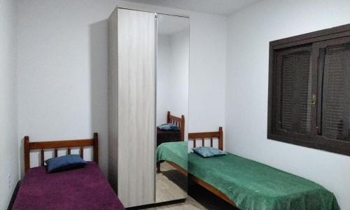 un espejo en una habitación con 2 camas. en Tenda Caiu do Céu, en Osório