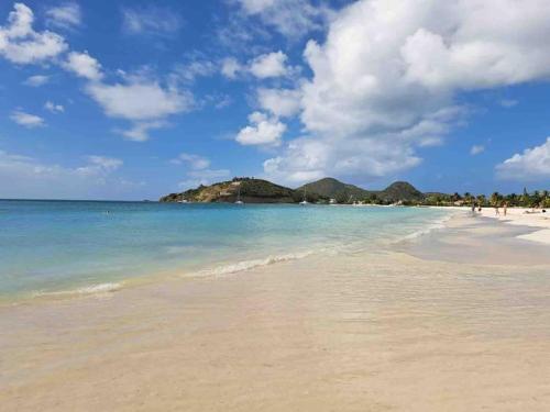 vistas a una playa con gente en el agua en Sugarhill Villa, en Jolly Harbour