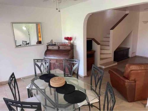 a living room with a glass table and a piano at Sugarhill Villa in Jolly Harbour