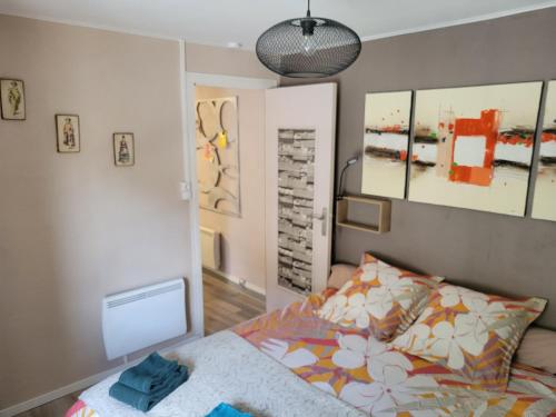 een slaapkamer met een bed en schilderijen aan de muur bij La casa di Giulietta in Saint-Just-Malmont