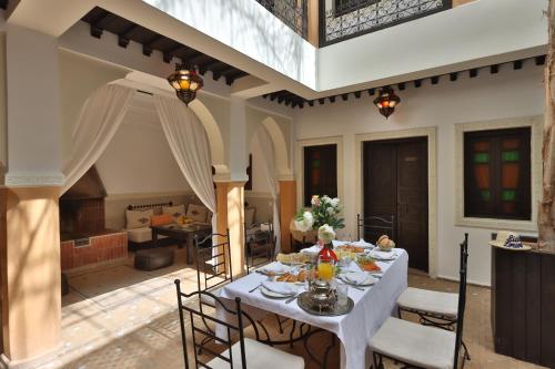 Riad 22 - L'Etoile d'Orient في مراكش: غرفة طعام مع طاولة بيضاء وكراسي
