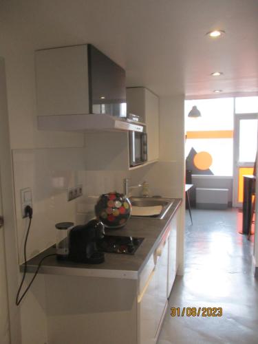 une cuisine avec un évier et un plan de travail dans l'établissement STUDIO ORANGE CINEMATIC 59, à Charleville-Mézières