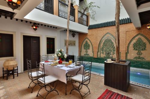 een eetkamer met een tafel en een zwembad bij Riad 22 - L'Etoile d'Orient in Marrakesh