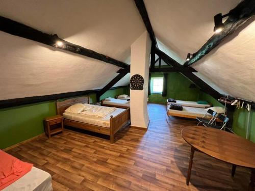 een zolderkamer met een bed en een tafel bij Le Gite De Malchamps in Spa