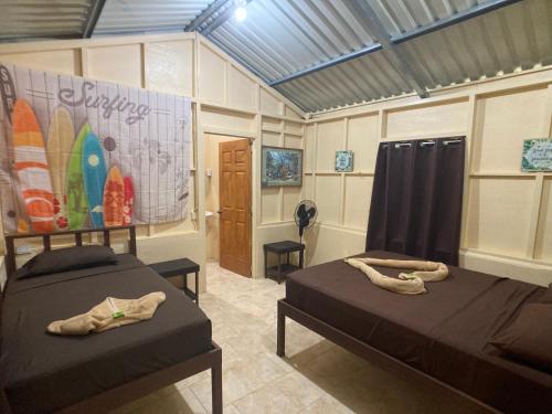two beds in a room with surfboards on the wall at YEJOS Jungle Lodge in Dos Brazos