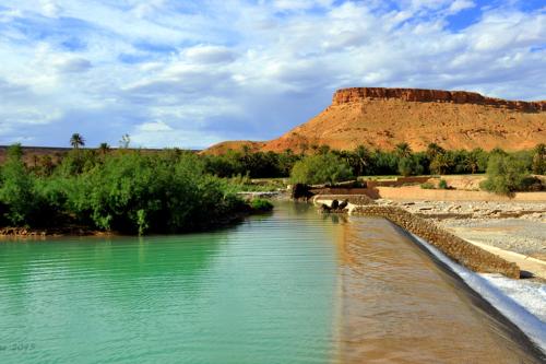 um rio no deserto com uma montanha ao fundo em HÔTE SAHARA em Goulmima