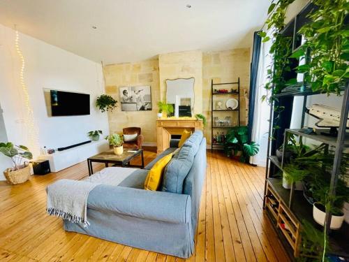 - un salon avec un canapé bleu et une table dans l'établissement Appartement au cœur de Bordeaux, à Bordeaux