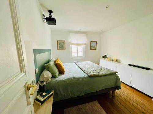 - une chambre avec un lit vert et une fenêtre dans l'établissement Appartement au cœur de Bordeaux, à Bordeaux
