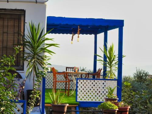 a blue gazebo with a table and chairs at Beit Philodemus in Um Qeis