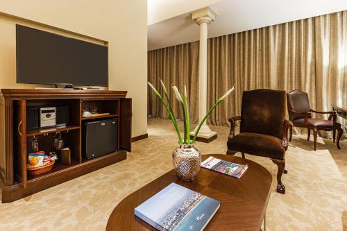 a living room with a television and a table and a chair at Country Club Lima Hotel – The Leading Hotels of the World in Lima
