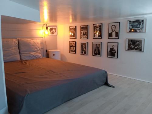 een slaapkamer met een bed met foto's aan de muur bij STUDIO ORANGE CINEMATIC 59 in Charleville-Mézières