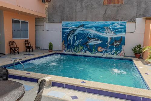 una piscina con un mural de delfines en San Alejo Zero, en San Jacinto