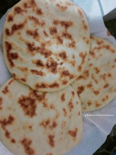 three tortilla pizzas sitting on a piece of paper at Pergolas Tamakouchte in Ouarzazate