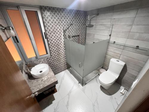 a bathroom with a shower and a toilet and a sink at Hosteleria Casa Margarita in Mazatlán