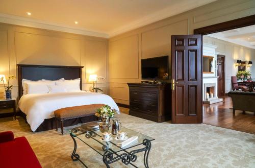 a bedroom with a large bed and a living room at Country Club Lima Hotel – The Leading Hotels of the World in Lima