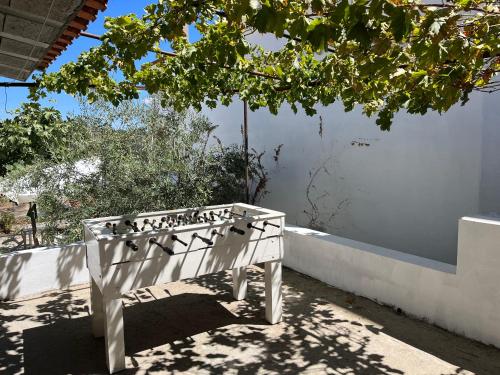 a white bench sitting next to a white wall at Casa da Avó Maria, Largo de Santo António, n 97395AL in Freixo de Espada à Cinta