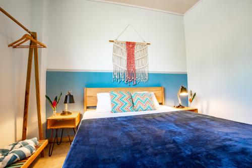 - une chambre bleue et blanche avec un grand lit dans l'établissement Selina Bocas del Toro, à Bocas del Toro