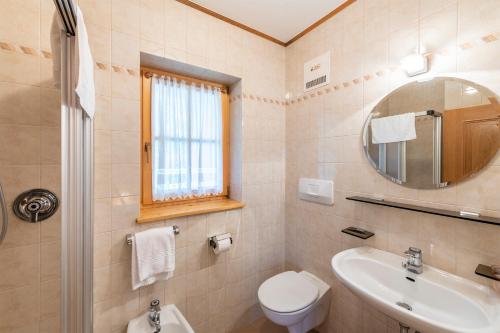 a bathroom with a sink and a toilet and a mirror at APPARTAMENTI FORTAREL in Prato alla Drava