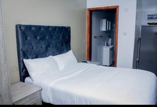 a white bed with a black headboard in a room at Onelove Homes in Lusaka
