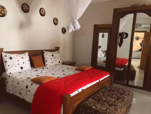 1 dormitorio con cama y espejo grande en Résidence Le Marlodj, en Mar Lodj