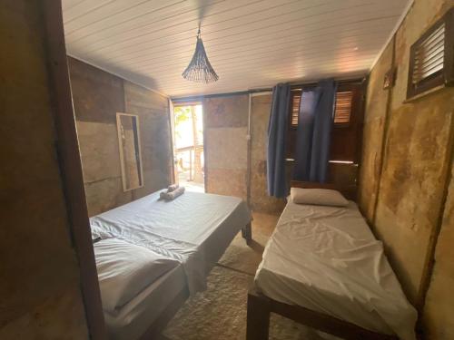 Cette petite chambre comprend 2 lits. dans l'établissement EKO CHALÉS, à Atins
