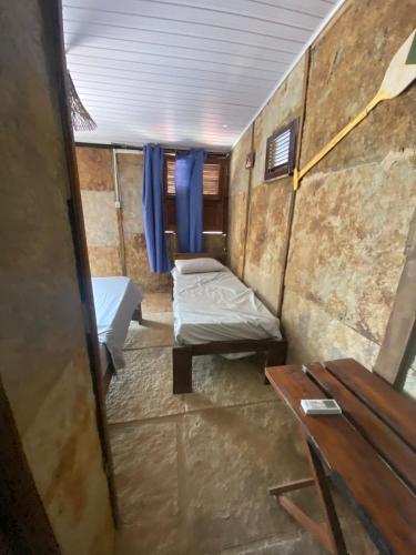 um pequeno quarto com duas camas e uma mesa em EKO CHALÉS em Atins