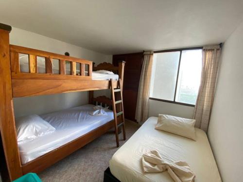 deux lits superposés dans une chambre avec fenêtre dans l'établissement Hermoso con Piscina y playa al lado del comercio del Rodadero, à Gaira