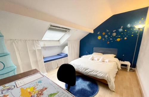 - une chambre avec un lit et un mur bleu dans l'établissement La Casa - Charmante maison entre Paris & Disney, à Noisy-le-Grand