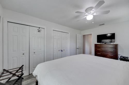 a bedroom with a white bed and a ceiling fan at Palm Harbor Estate w/ Pool & Fruit Trees on Acre in Palm Harbor