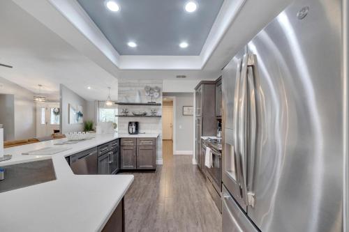 a large kitchen with a stainless steel refrigerator at Palm Harbor Estate w/ Pool & Fruit Trees on Acre in Palm Harbor