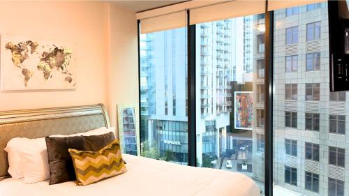 a bedroom with a bed and a large window at The Luxe -Highrise, Balcony, Pool, City View! in Atlanta