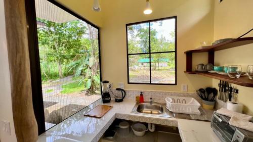 a kitchen with a sink and a large window at Awake Uvita in Uvita