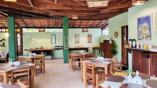 ein Restaurant mit Holztischen und -stühlen in einem Zimmer in der Unterkunft Pousada Vila dos Passaros in Itacaré