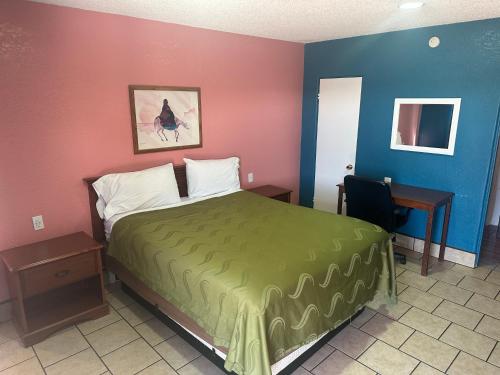 a hotel room with a bed and a desk at Western Inn Roswell in Roswell